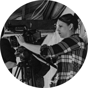 side profile of a woman behind a film camera