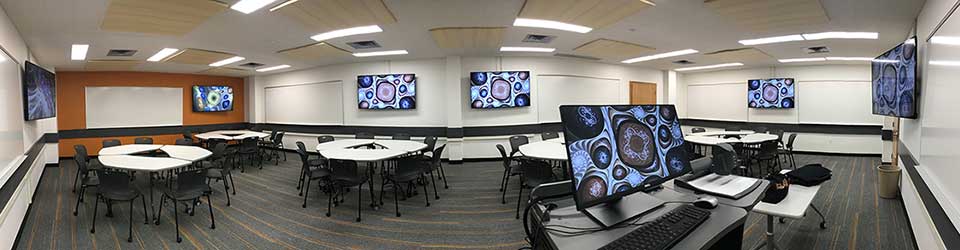 Reid 332 with an instructor podium, 5 tables, wall displays, and whiteboards